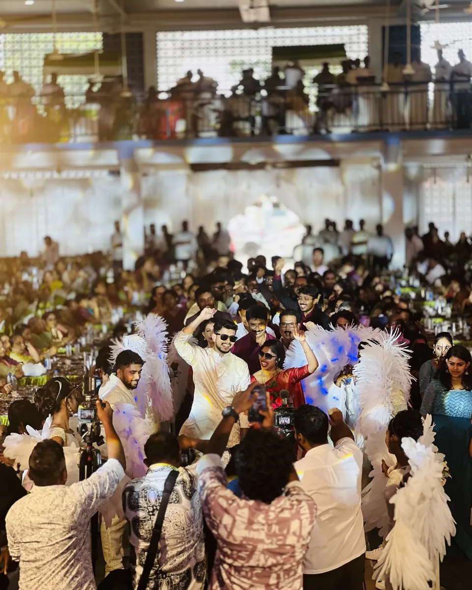 Grand entry of the couple through a packed reception hall